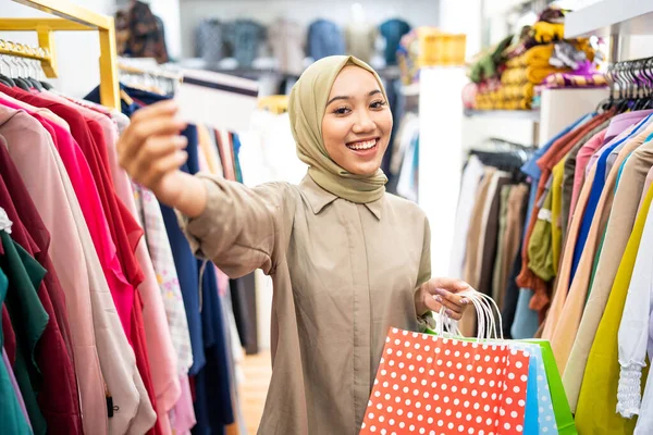 Excited muslim woman with paper bag and credit card — Stock Photo, Image