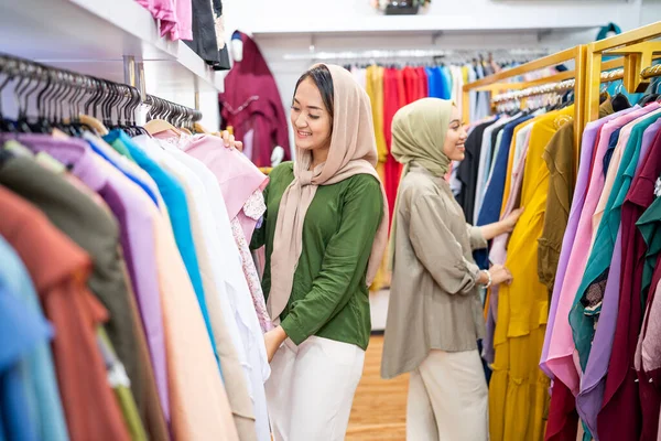 Belle femme musulmane avec foulard à la tête regardant une robe — Photo