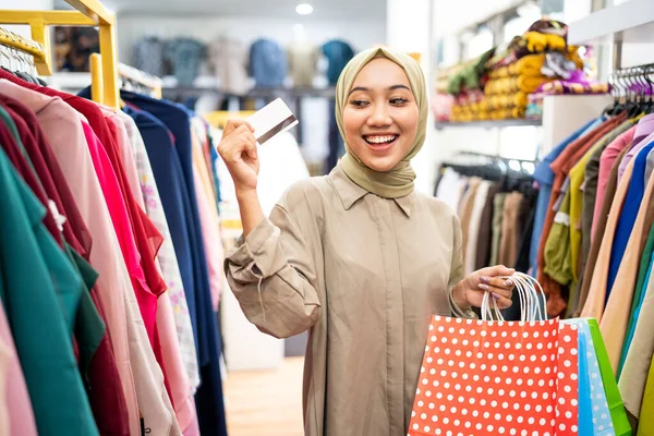 Aufgeregte Muslimin mit Papiertüte und Kreditkarte — Stockfoto