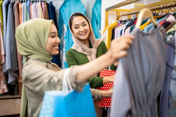Мусульманська подруга купує нову сукню в магазині моди — стокове фото