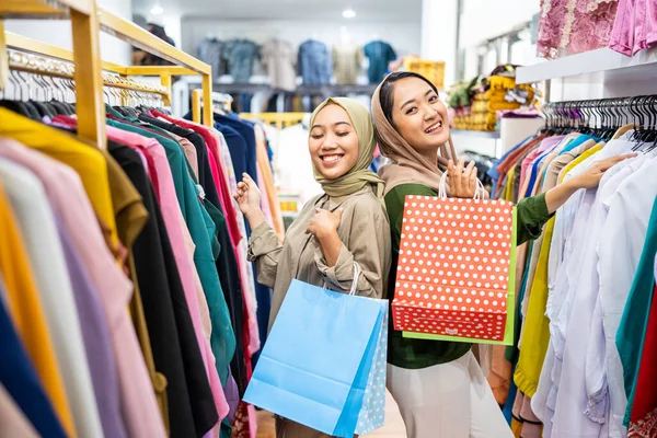 Musulmane amie acheter nouvelle robe au magasin de mode — Photo