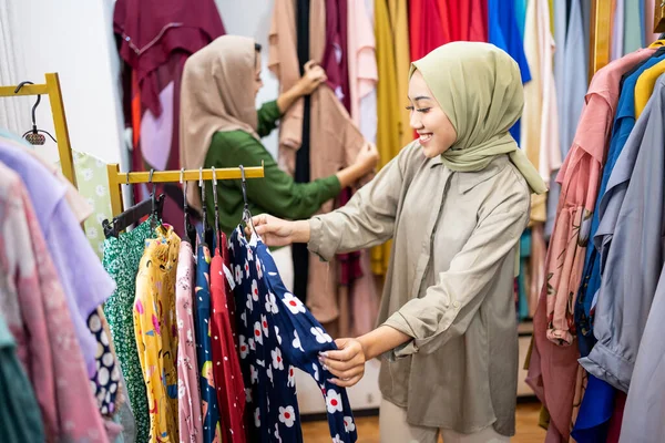 Müslüman kadın arkadaşıyla moda mağazasından yeni elbiseler alıyor. — Stok fotoğraf