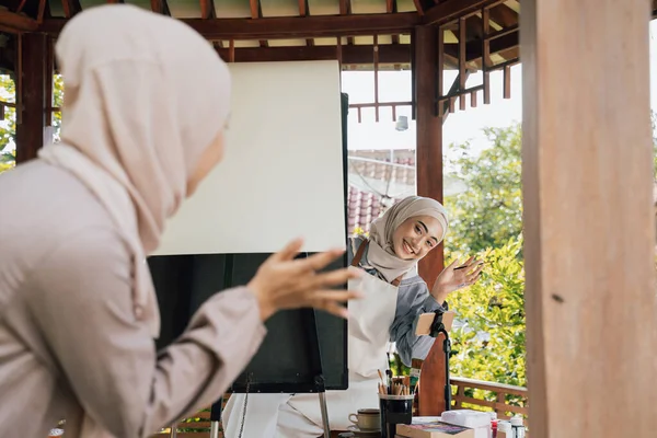 Muslim žena umělkyně setkání její přítel při práci v její dílně — Stock fotografie