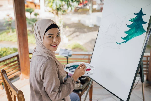 Μουσουλμάνα ζωγράφος ζωγραφίζει σε καμβά στο εργαστήριό της — Φωτογραφία Αρχείου