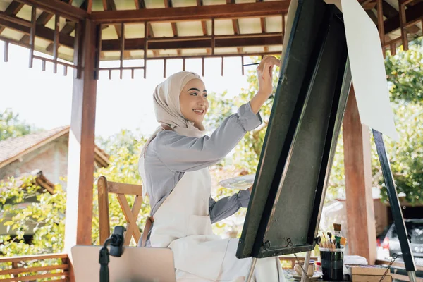 Muslim Žena umělkyně malba na plátně v domácím studiu — Stock fotografie