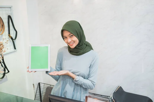 Proprietário de loja de moda muçulmana de pé como um caixa segurando um tablet pc — Fotografia de Stock