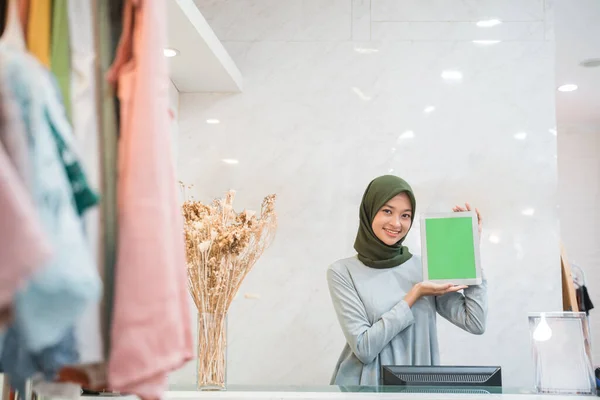 Proprietario di negozio di moda musulmano in piedi come cassiere in possesso di un tablet pc — Foto Stock