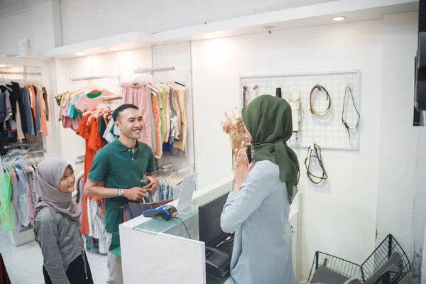 Zahalené obchodní žena se usmívá s pozdravem pro svého zákazníka v obchodě — Stock fotografie