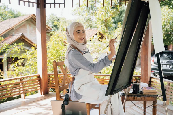 Muslimka malířka na plátně ve své dílně — Stock fotografie