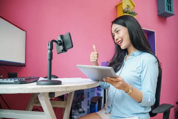 Freelancer vrouw werken met behulp van telefoon met duimen omhoog hand gebaar — Stockfoto
