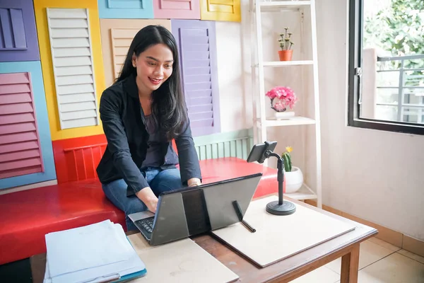 Frilansande asiatisk kvinna som arbetar med bärbar dator och Urklipp under mötet — Stockfoto