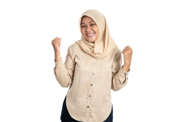 Возбужденная молодая женщина в хиджабе сжимает руки, празднуя успех — стоковое фото