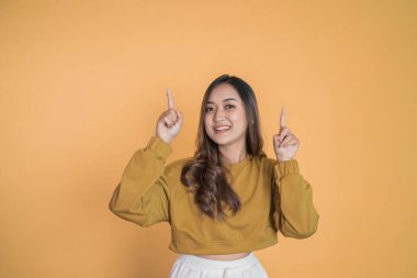 Sarı tişörtlü genç bir kadın parmak kaldırıyor.