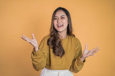 Heyecanlı genç kadın kameraya gülümserken iki avucunu da açıyor.