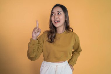 Genç bir kadın işaret ederek el hareketi yapıyor.