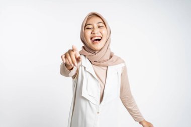 Parmakla işaret eden Müslüman kadın bir şeye gülüyor.