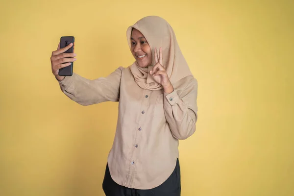 Tesettürlü Asyalı kadın selfie için akıllı bir telefon tutuyor. — Stok fotoğraf