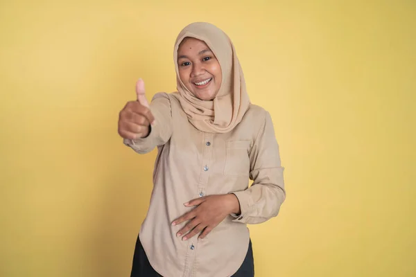 Aziatische vrouw in hijab glimlachen met duimen omhoog terwijl staande — Stockfoto