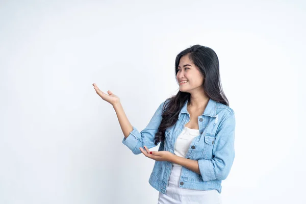 Azji dziewczyna z gestem ręki prezentując coś na odosobnionym tle — Zdjęcie stockowe