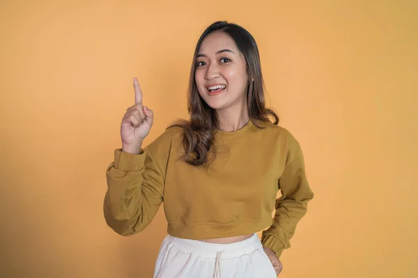 Lächelnde junge Frau mit erhobenem Zeigefinger — Stockfoto