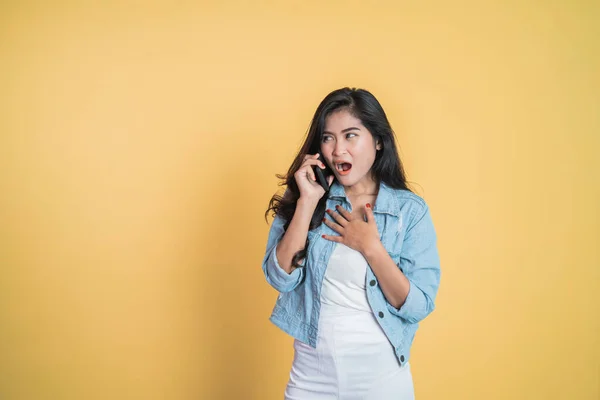Überrascht asiatische Frau macht einen Anruf mit einem Handy — Stockfoto