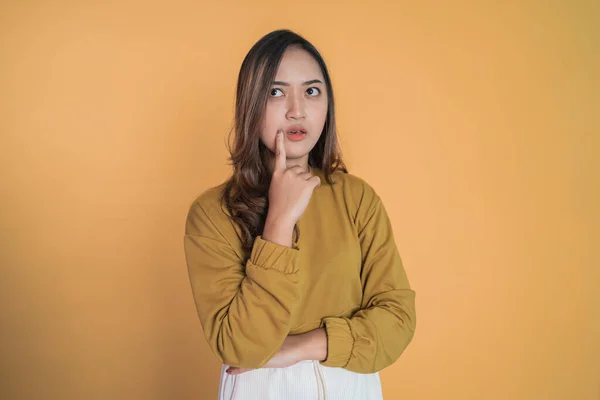 Junge asiatische Frau denkt etwas mit Finger Geste hält Wange — Stockfoto