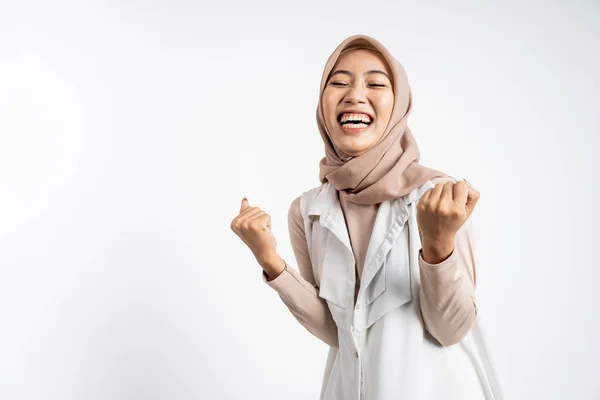 Mujer en hijab apretando las manos mientras celebra el éxito — Foto de Stock