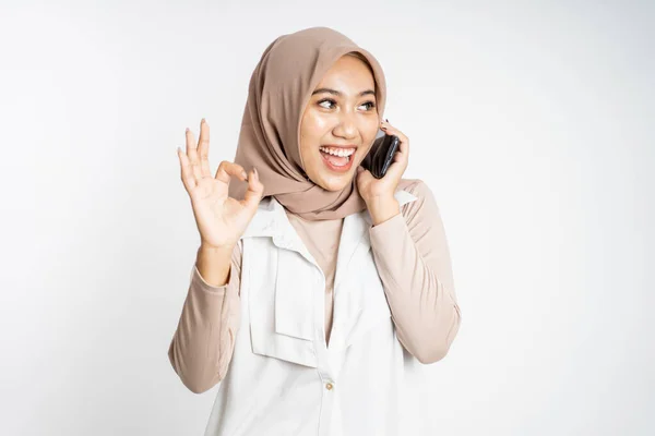 Mulher fazendo uma chamada usando um telefone celular e mostrando o polegar para cima — Fotografia de Stock