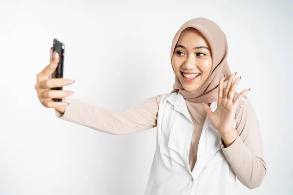 Mujer en hijab sosteniendo un teléfono inteligente para selfie —  Fotos de Stock