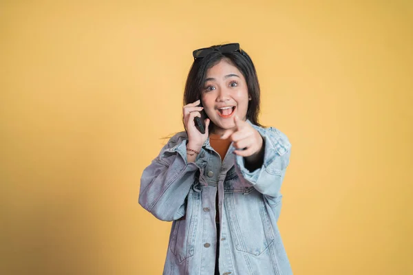 Ung kvinna ringer ett samtal med fingret pekande — Stockfoto