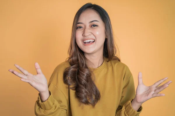 Izgatott fiatal ázsiai nő nyitja mindkét tenyerét, miközben mosolyog — Stock Fotó