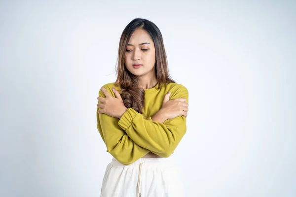 Mladá žena cítí chlad s oběma rukama objímající její paže — Stock fotografie