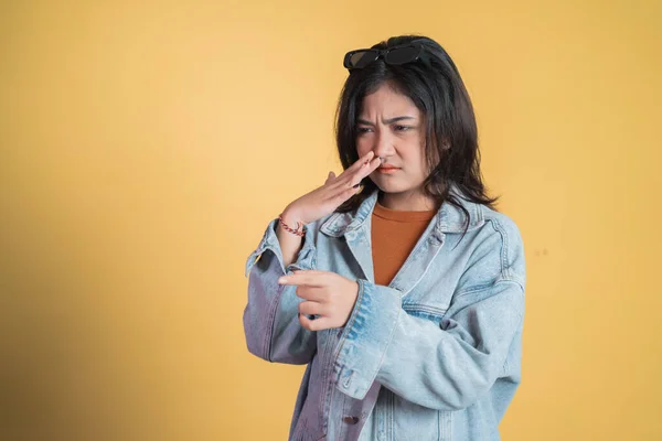 Junge Frau deckt Nase bei üblem Geruch mit Finger zu — Stockfoto