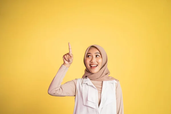 Sorrindo mulher hijab com o dedo apontando para cima gesto da mão — Fotografia de Stock