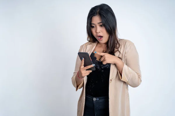 Jovem chocada com o dedo apontando usando um telefone celular — Fotografia de Stock