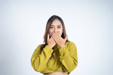 Ağzını kapatan elleri ile şok olmuş genç bir kadın.