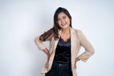 Genç Asyalı kadın elleri belinde duruyor.