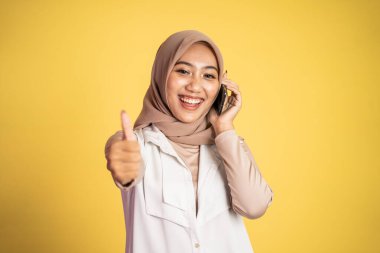 Kadın cep telefonuyla arama yapıyor ve parmağını kaldırıyor.