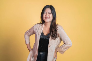 Genç Asyalı kadın elleri belinde duruyor.