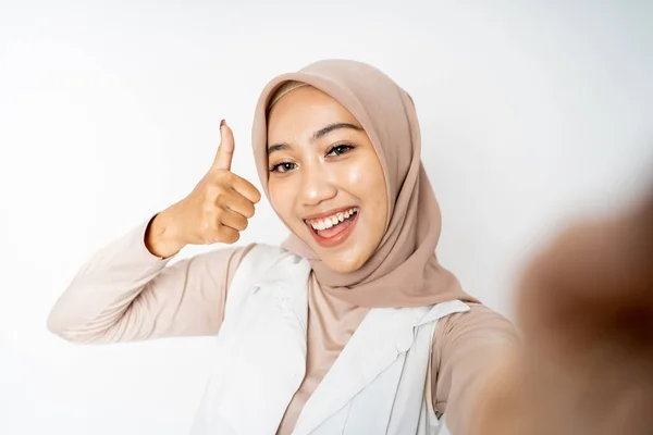 Kobieta w hijab trzyma smartfon dla selfie kciuk w górę — Zdjęcie stockowe