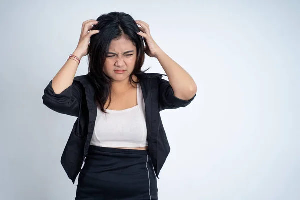 Молодая женщина держит голову с головной болью на изолированном фоне — стоковое фото