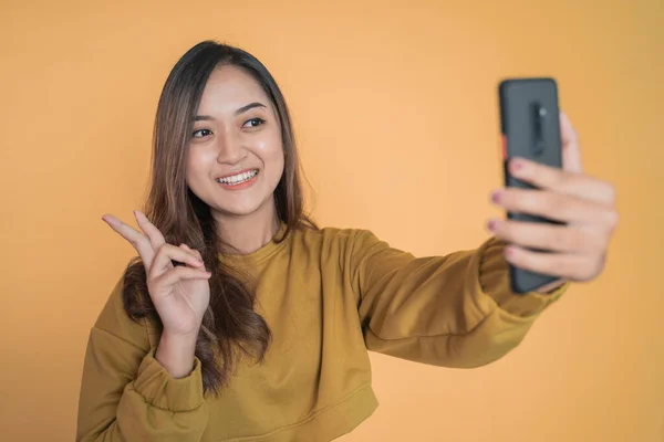 Vacker ung kvinna selfie med hjälp av telefon kamera med v tecken — Stockfoto