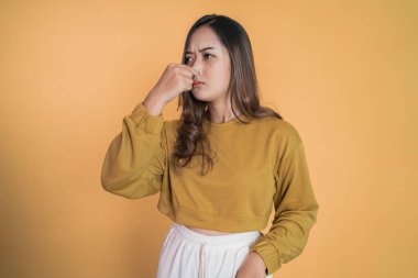 Kötü koktuğunda burnunu parmağınla kapatan genç bir kadın.