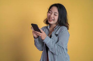 Genç Asyalı kadın cep telefonu kullanıyor SMS mesajı yazıyor