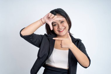 Bir çerçeve oluşturan parmaklar arasından bakan genç bir kadın