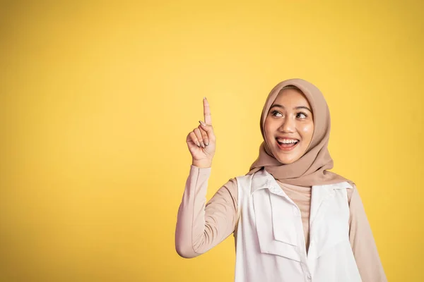 Mujer hijab sonriente con el dedo apuntando hacia arriba gesto de la mano — Foto de Stock