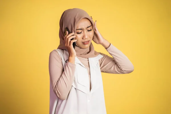 Mulher muçulmana preocupado no hijab fazendo uma chamada usando um telefone celular — Fotografia de Stock