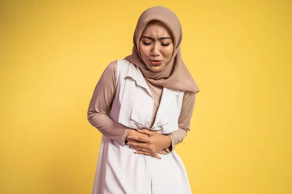 Muszlim nőnek mindkét kezével fáj a gyomra, ha fáj a gyomra. — Stock Fotó