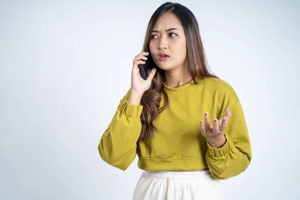 Mulher zangada fazendo uma chamada usando um smartphone — Fotografia de Stock