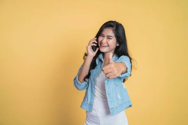 Jonge aziatische vrouw het maken van een gesprek met behulp van een mobiele telefoon met duimen omhoog — Stockfoto